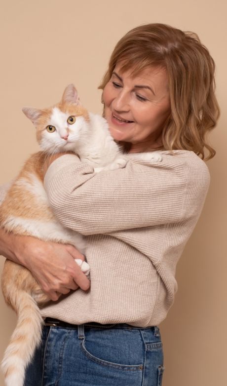 Woman holding orange and white cat